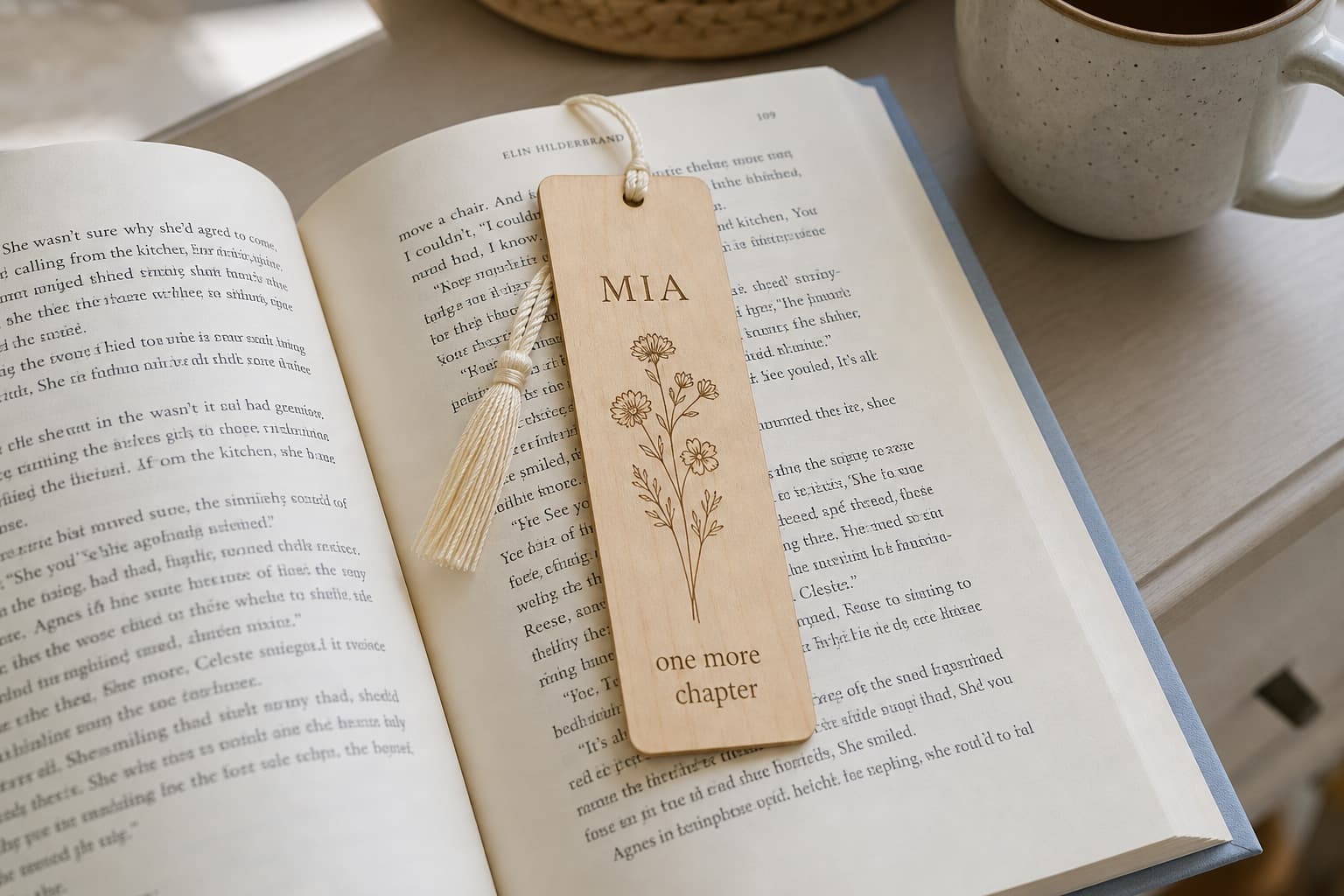 Personalized maple bookmark resting inside an open book on a bedside table