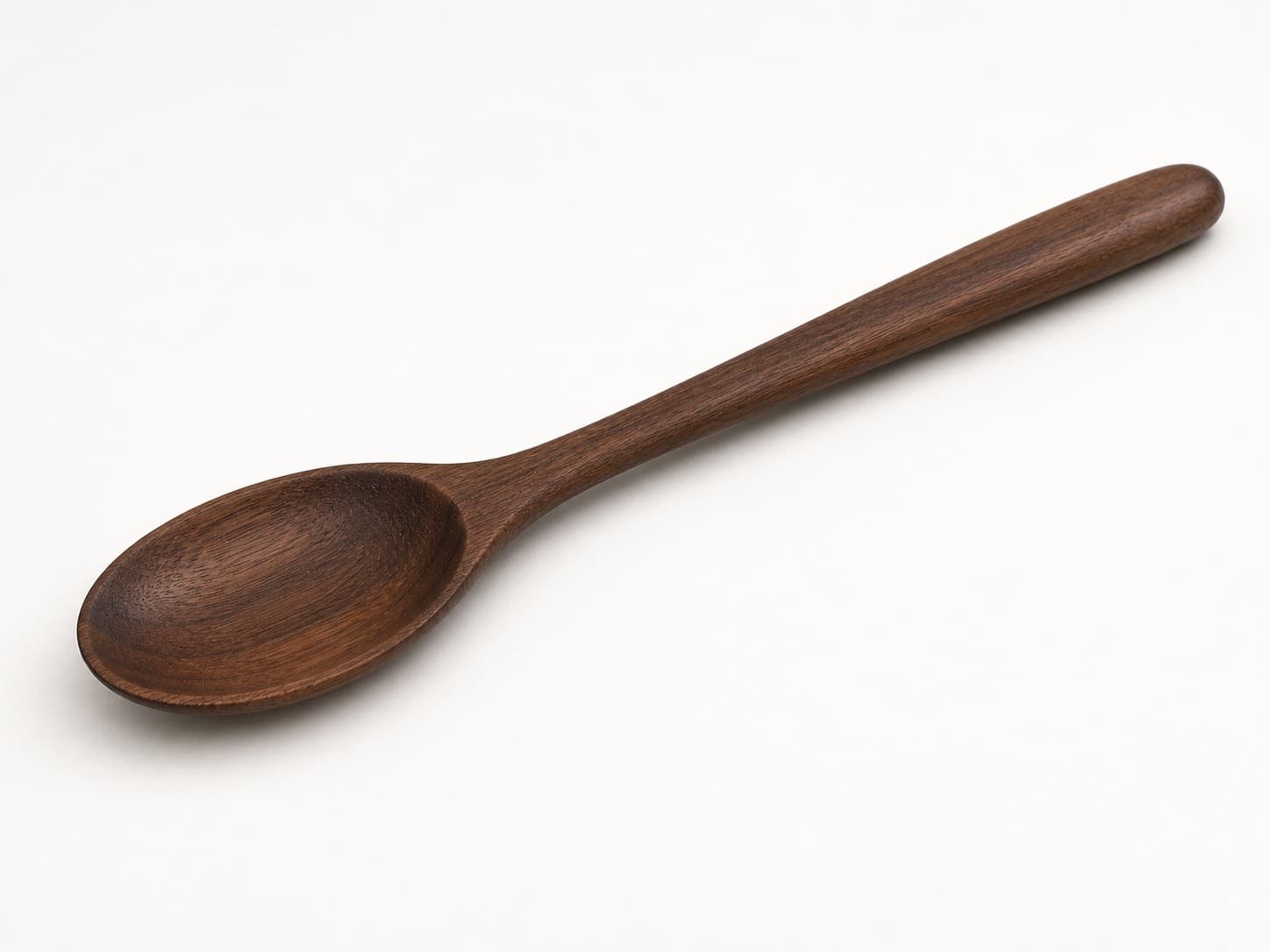 Classic cooking spoon with rounded bowl and long handle shown in black walnut